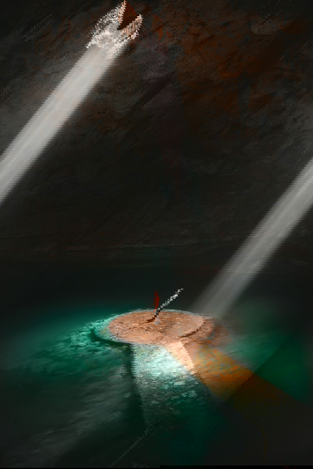 person standing on brown platform under water lake